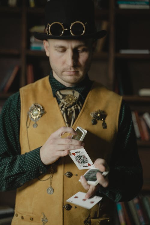 Free Photo of a Man in a Vest Doing Card Tricks Stock Photo