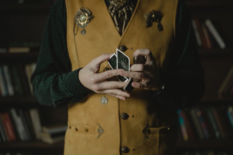 Photo Of A Person In A Vest Doing Card Tricks