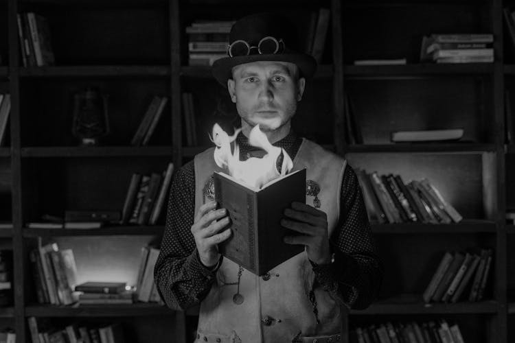 An Illusionist Holding A Burning Book