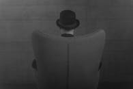 A Person with a Hat Sitting on a Chair