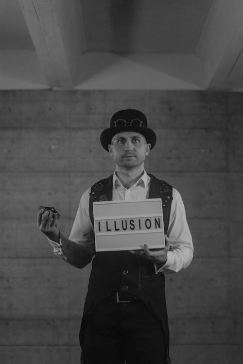 Grayscale Photography of a Magician Holding a Letterboard
