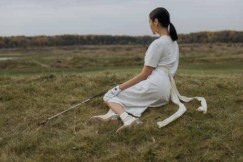 A Woman wearing White Dress Sitting on the Grass