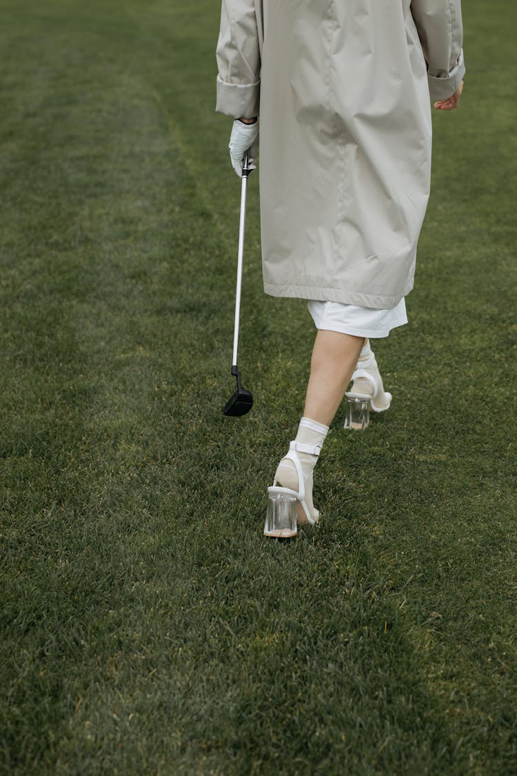 Person In High Heels Walking On Golf Field