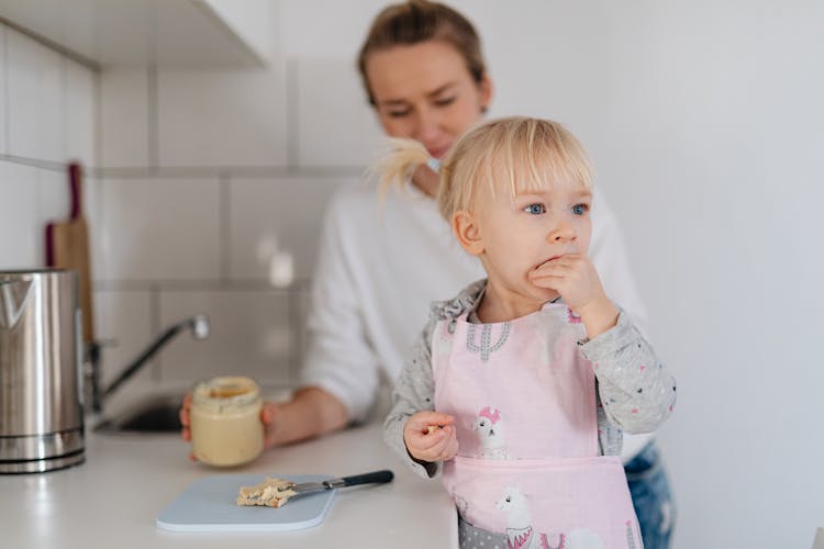 Mother And Daughter Eating In A Kitchen