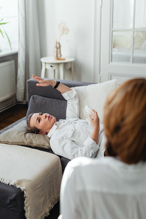 Woman in White Long Sleeves Lying on Sofa