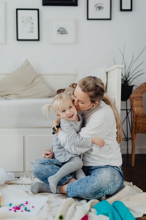 Free Mom Hugging and Kissing Her Daughter Stock Photo