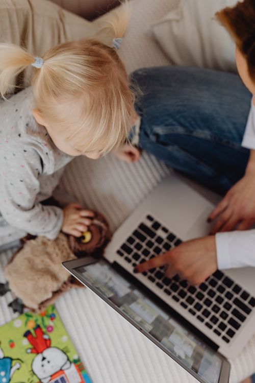 Free Overhead shot of mother and child bonding over a laptop, emphasizing family interaction. Stock Photo