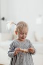 Girl in Gray Long Sleeve Shirt Holding Bread