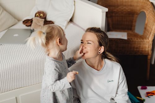 Free A mother and daughter enjoy a playful and loving moment in their cozy home setting. Stock Photo