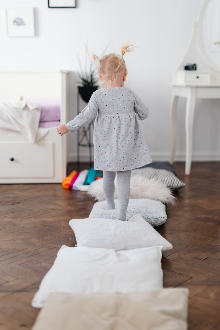 Little Girl Walking On Pillows