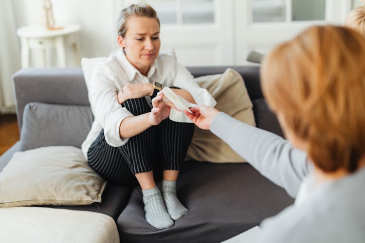 Woman Giving Tissues To A Sad Woman