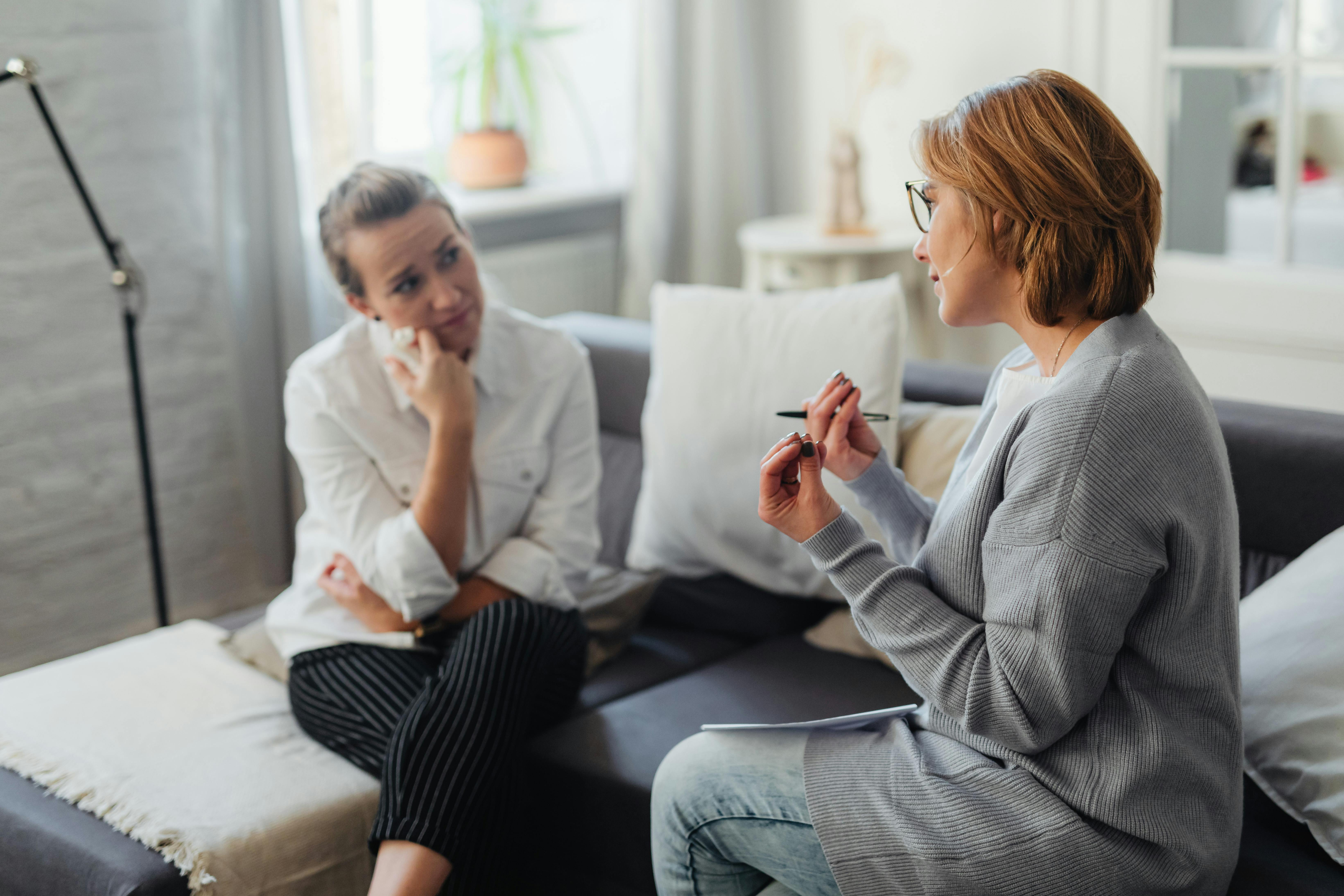 A compassionate therapist actively listening to a client during a therapy session - treatment for depression and anxiety
