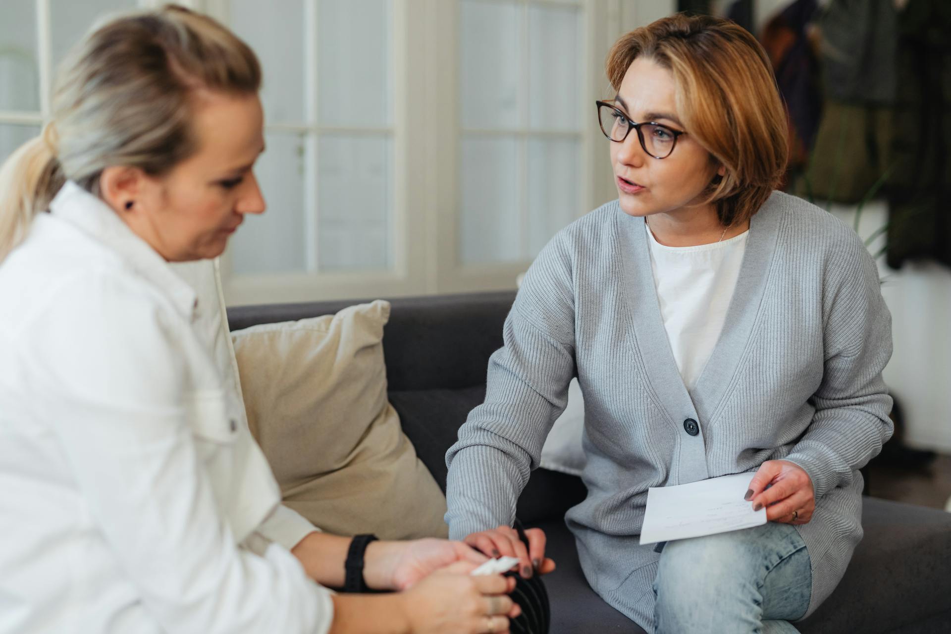 Woman Holding Another Womans Hand and Talking to Her