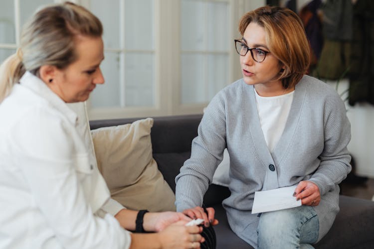 Woman Holding Another Womans Hand And Talking To Her 