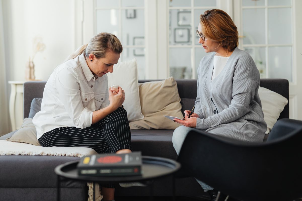 Patientin im Gespräch mit einem Therapeuten – Vertrauen und Kommunikation in der Physiotherapie