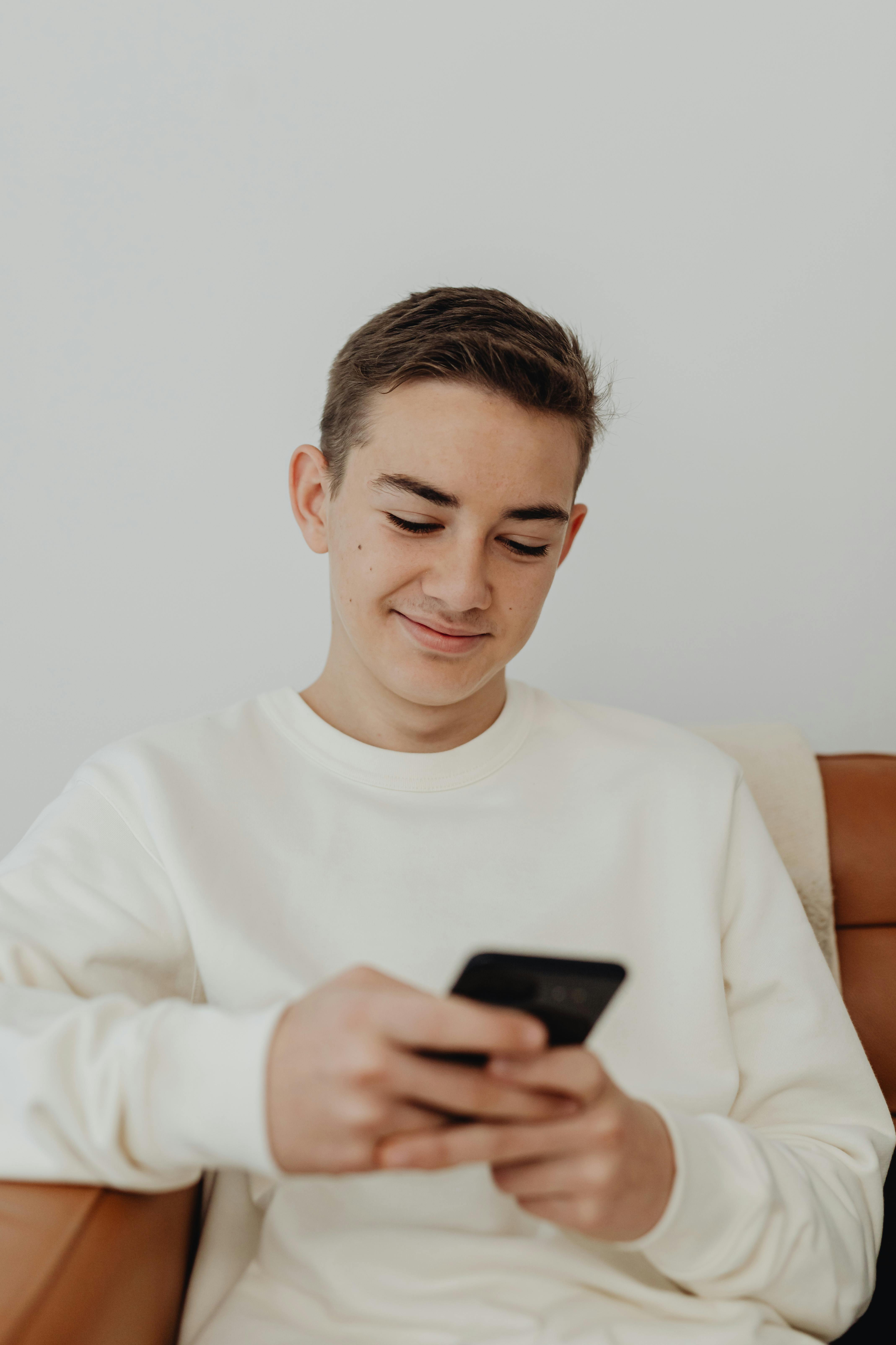 bezplatná Základová fotografie zdarma na téma #krytý, bílý svetr, chytrý telefon Základová fotografie