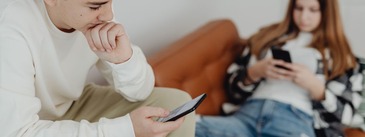 Dos adolescentes en un sofá mirando el móvil