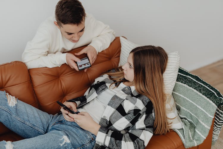 Teenage Couple Using Their Smart Phones 