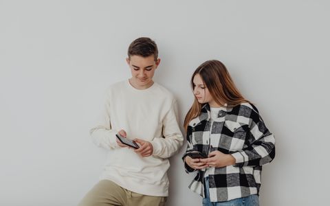 Dos adolescentes con sus móviles