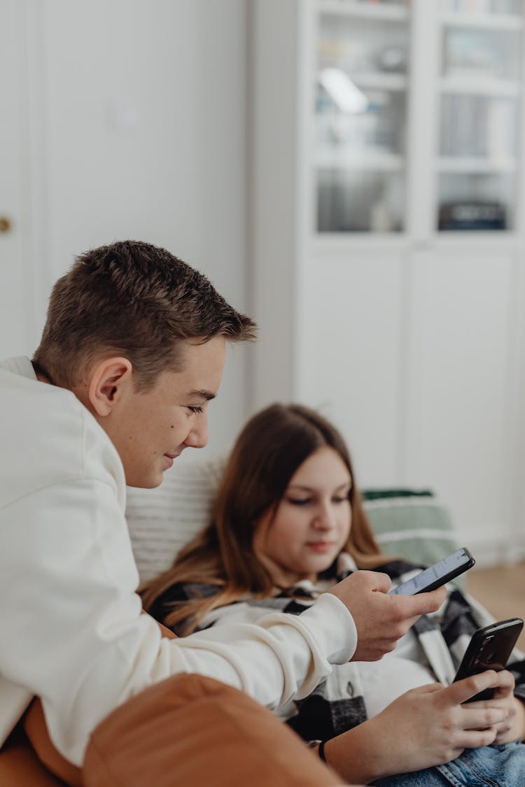 Couple Sitting Together And Using Smartphones