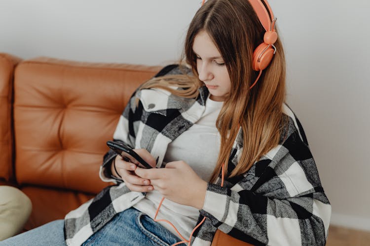 Girl In Headphones Using A Phone