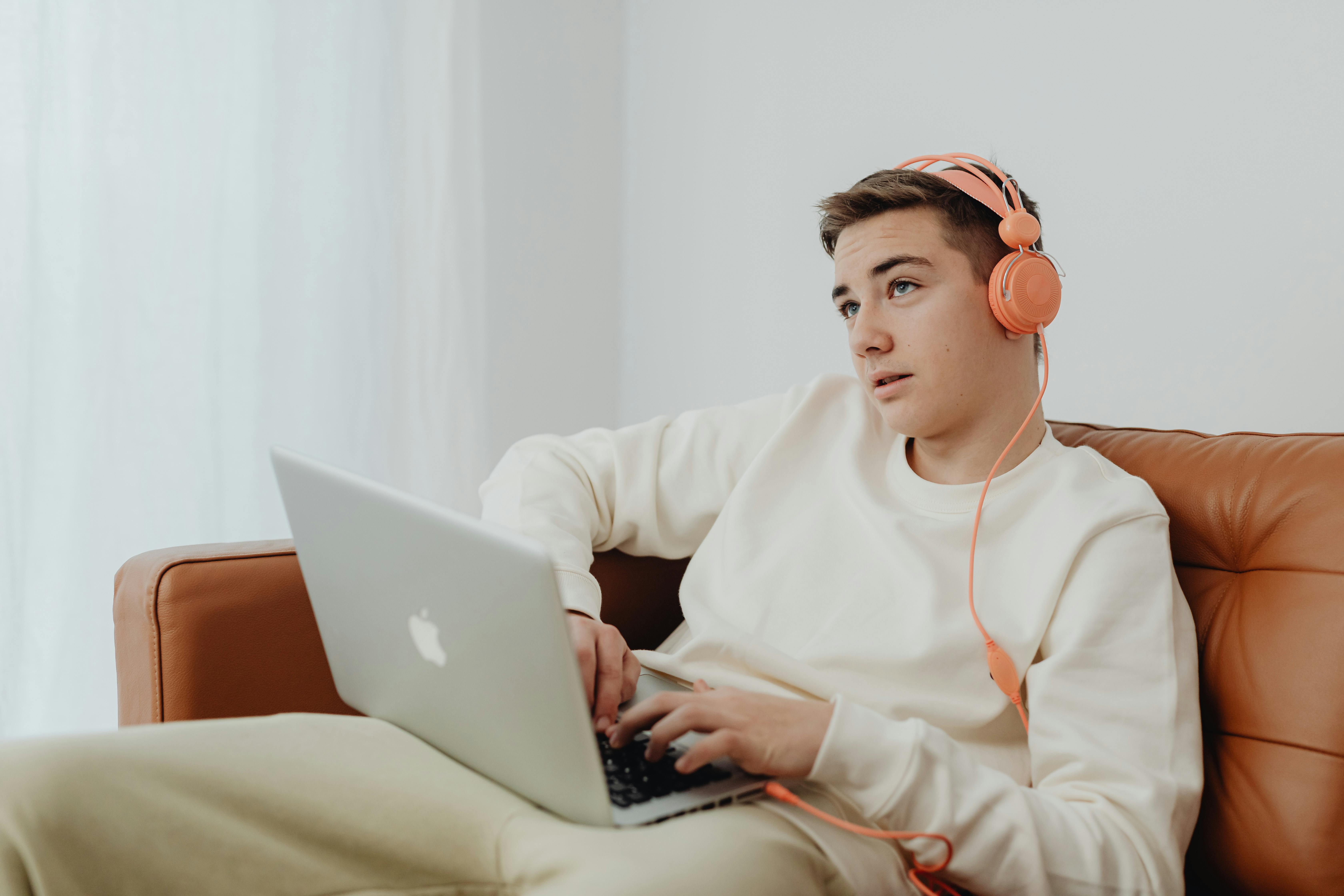 teenage boy using a laptop and headphones