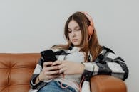 Teenage Girl Using Smart Phone with Headphones on