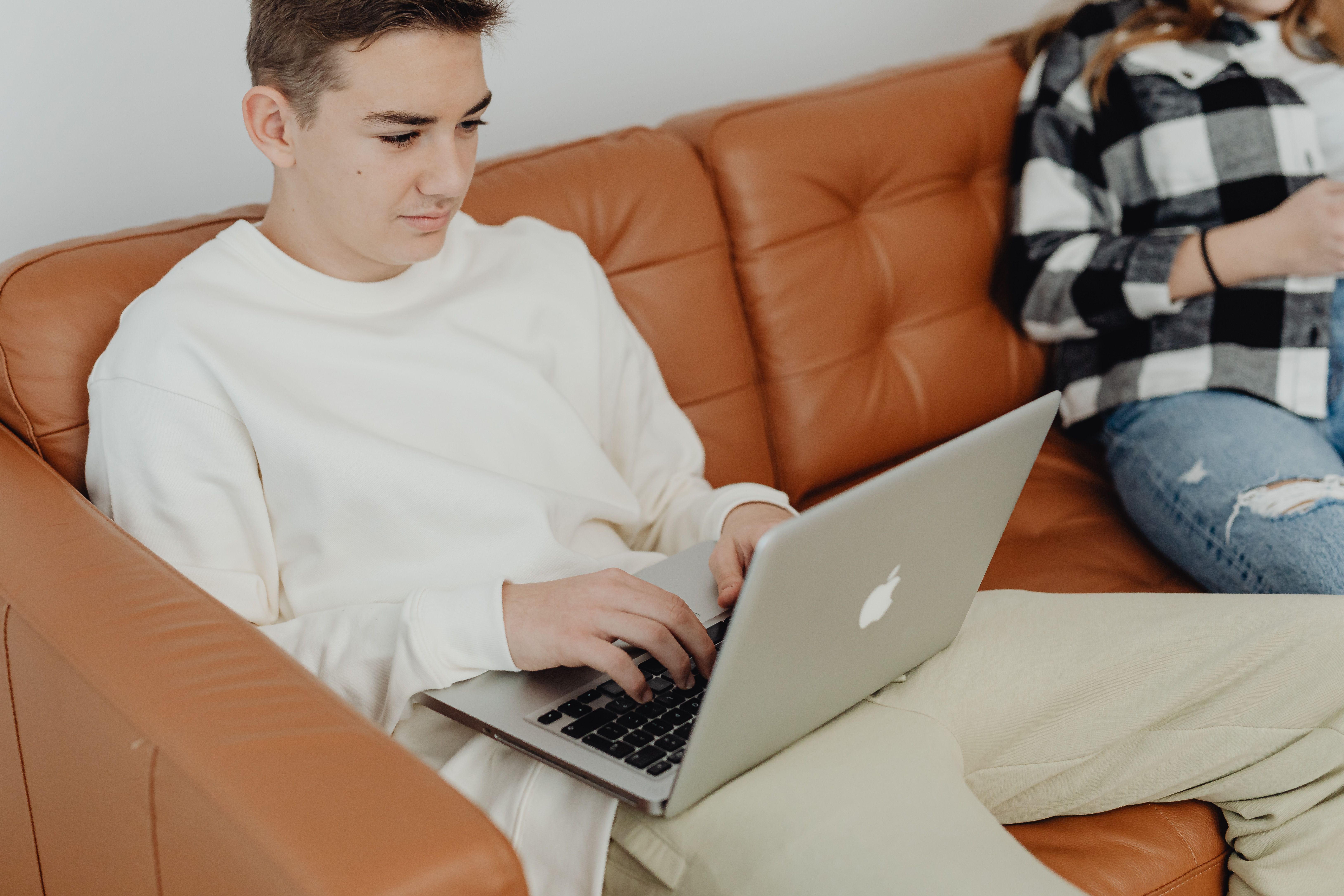 A student works through coursework on a laptop at home