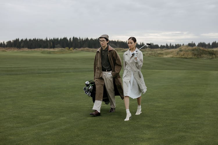 Man And Woman Walking In The Golf Course 