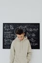 Teenage Boy Standing Next to the Blackboard