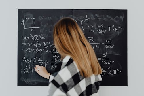 Free Woman Writing Trigonometry Calculations on Blackboard Stock Photo