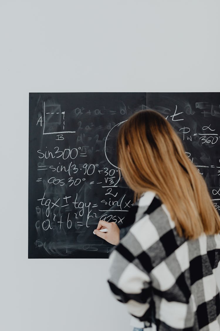 Teenage Girl Solving A Maths Task On The Blackboard 