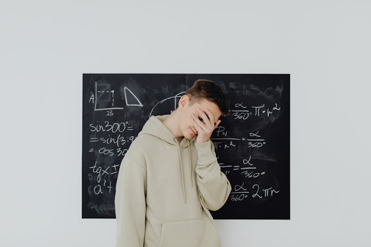 Boy In Beige Hoodie Covering His Face