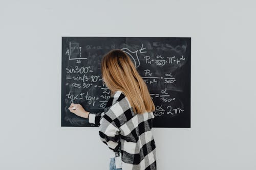 Free Girl in Plaid Shirt Solving a Math Problem Stock Photo