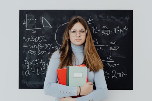 Portrait of a Female Student Standing in front of a Blackboard