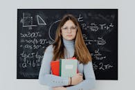 Portrait of a Female Student Standing in front of a Blackboard
