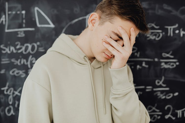 Overwhelmed Young Man Against Trigonometry Calculations