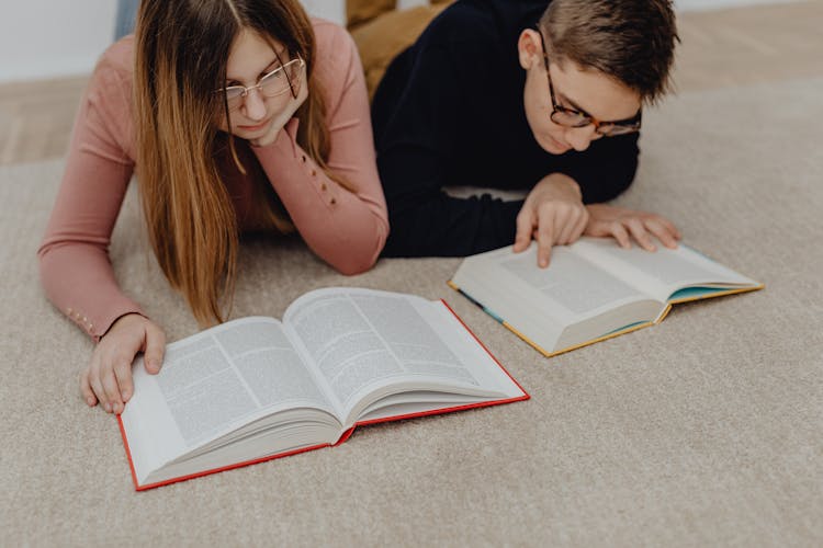 Teenage Boy And Girl Reading Books On The Floor