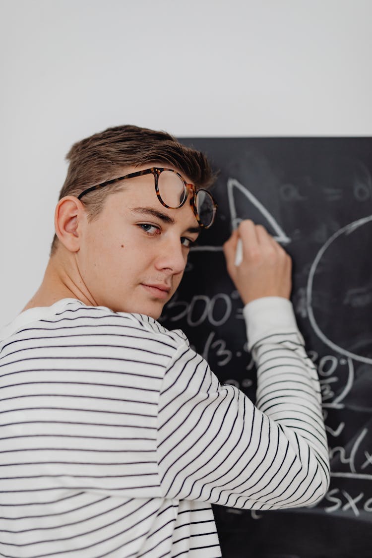 Boy Solving An Equation On A Blackboard 