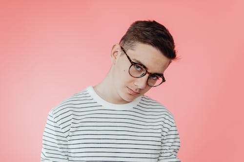 Portrait of a Teenage Boy Against a Pink Background