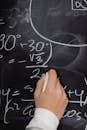 Close-up of a Person Solving and Equation on a Blackboard