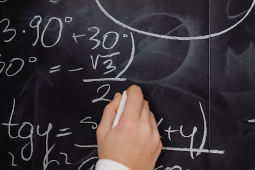 Free Hand Writing Mathematical Formulas on a Blackboard Stock Photo