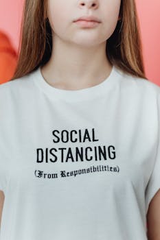 Close-up of white T-shirt with embroidered funny social distancing text.