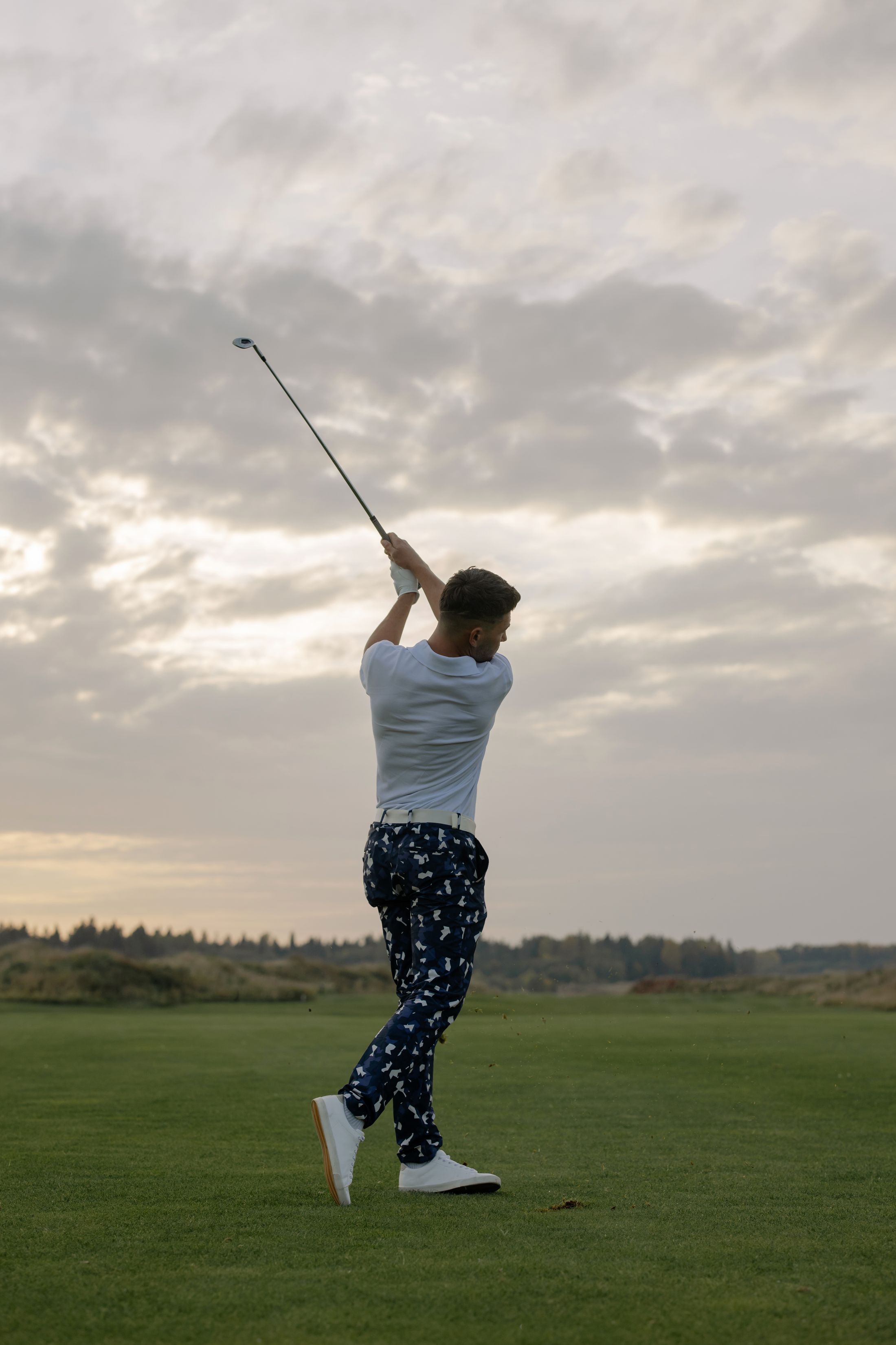 Golfer making a powerful full-speed swing on the course