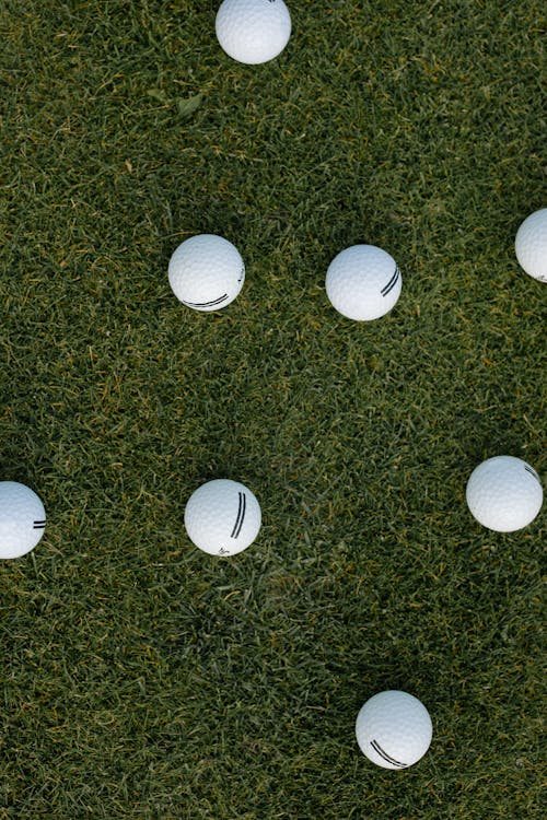 Белый мяч для гольфа на поле зеленой травы