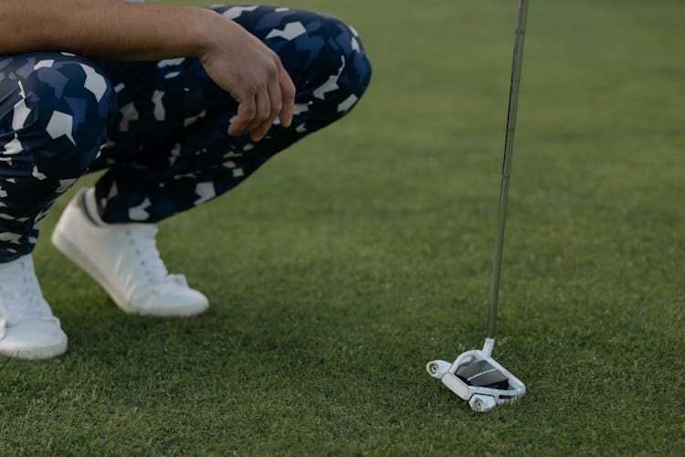 Person Playing Golf On Green Grass