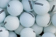 White Golf Ball Lot on Green Plastic Container