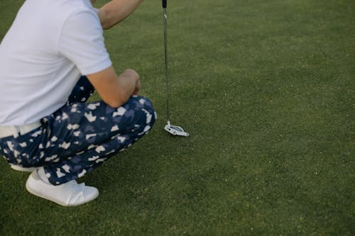 Free Person in White T-shirt and Blue and White Pants Holding Golf Club Stock Photo