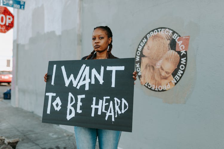 A Protester Holding Black Placard With Message