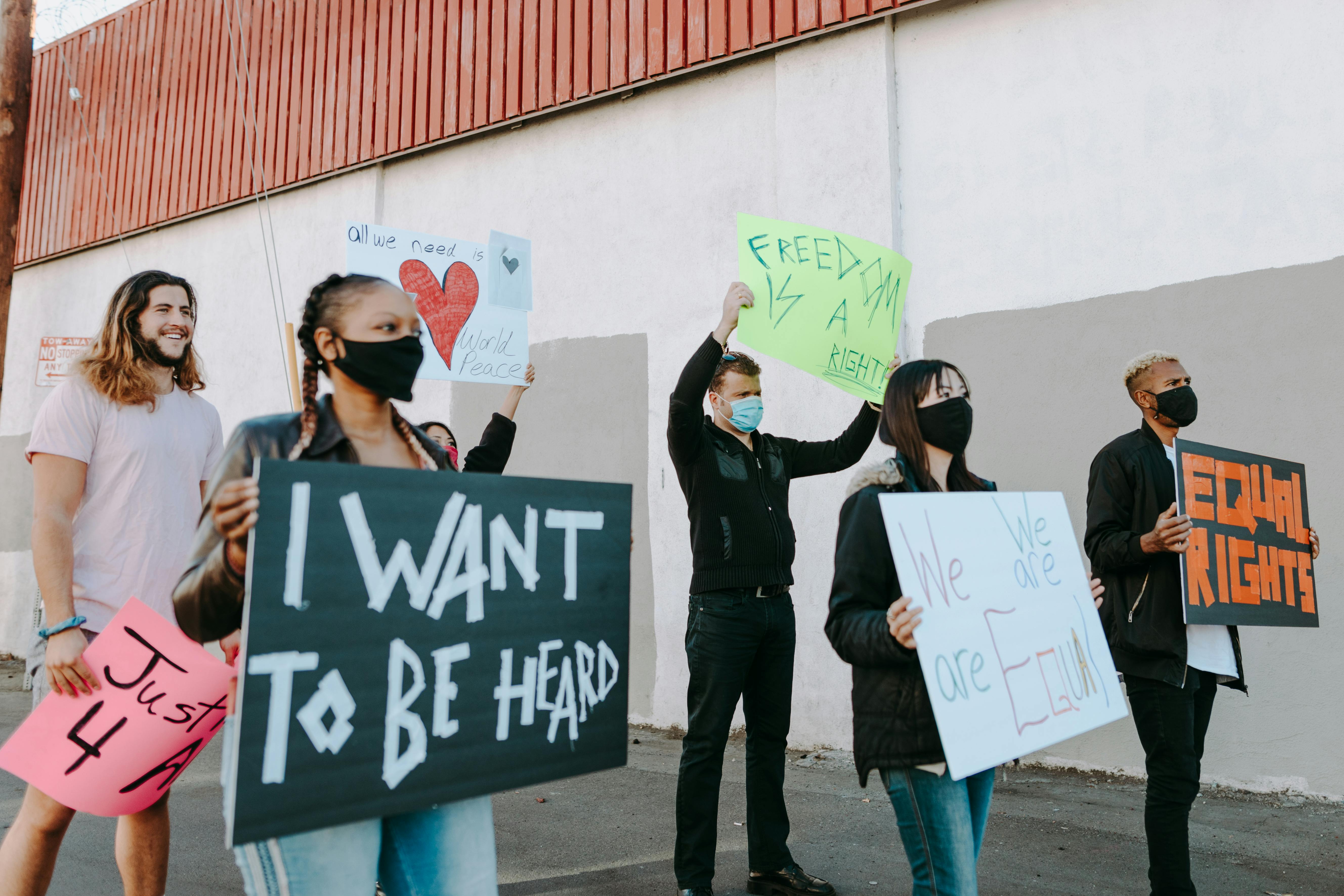 group of rallyists holding placards while walking on the street